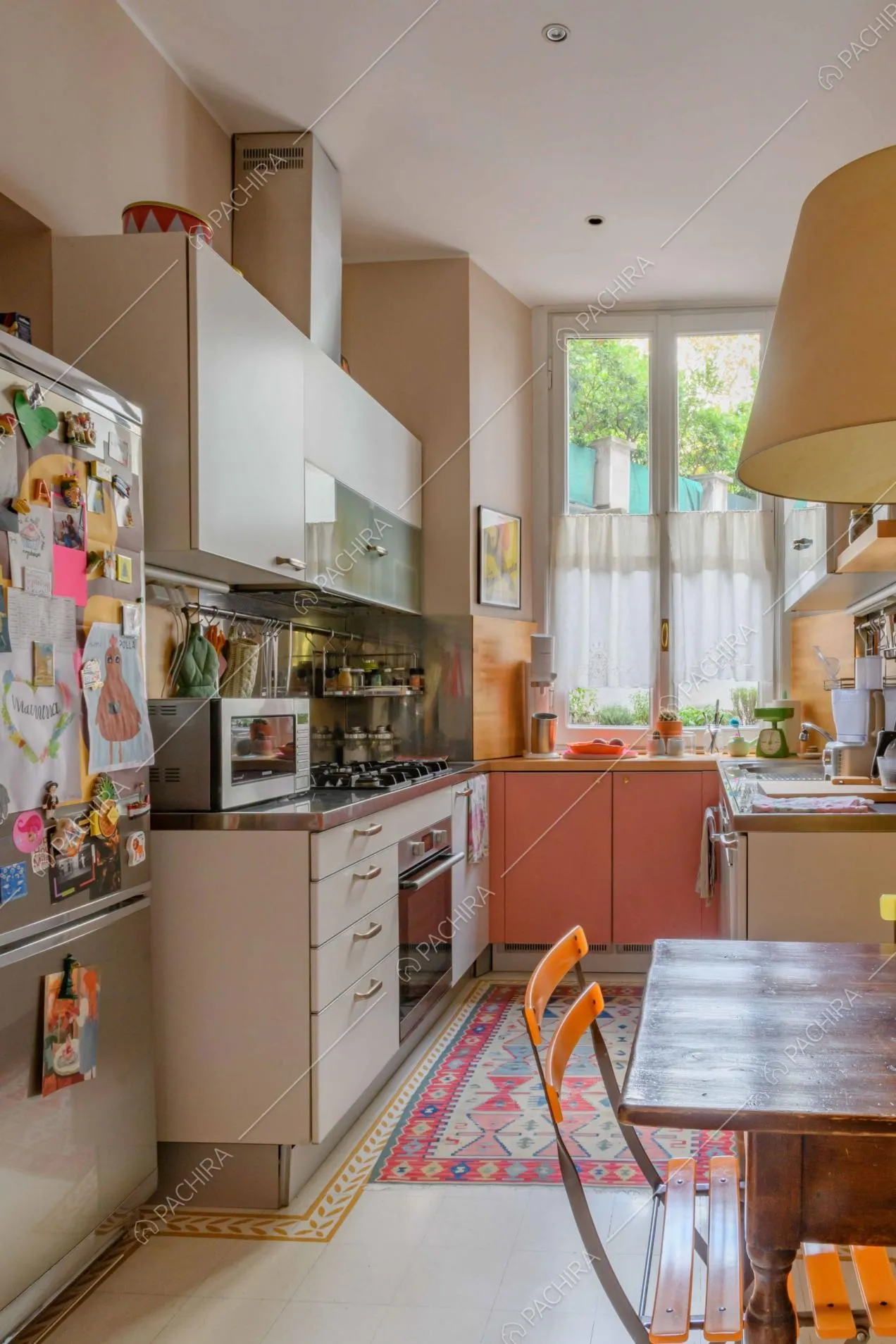 Cucina a parete con tavolo da pranzo in legno, fornelli a gas e paraschizzi in acciaio