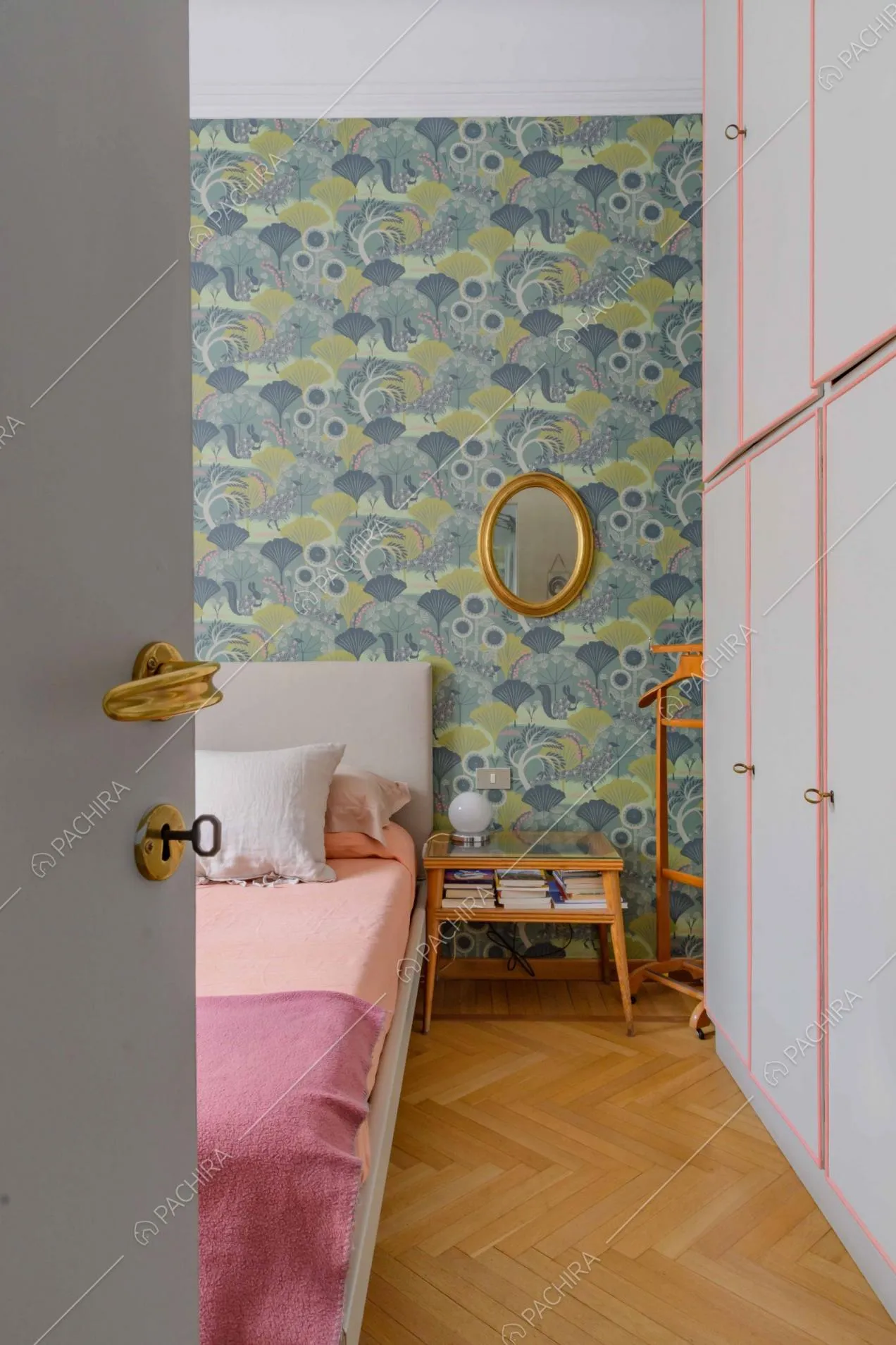 Vista sulla camera da letto con pavimento in parquet a spina di pesce, letto matrimoniale e carta da parati