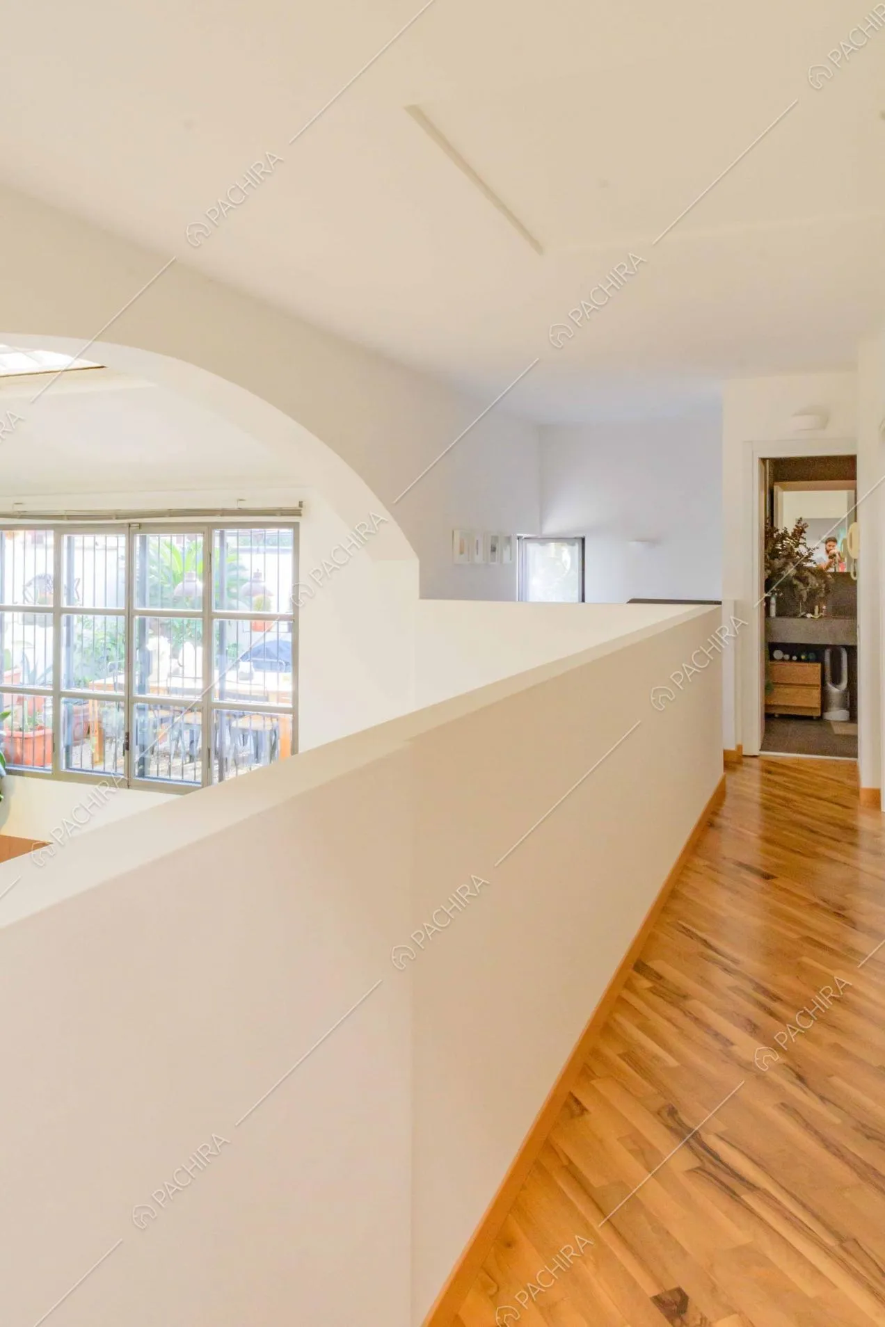 Luminoso soppalco con pavimento in parquet e vista sul bagno