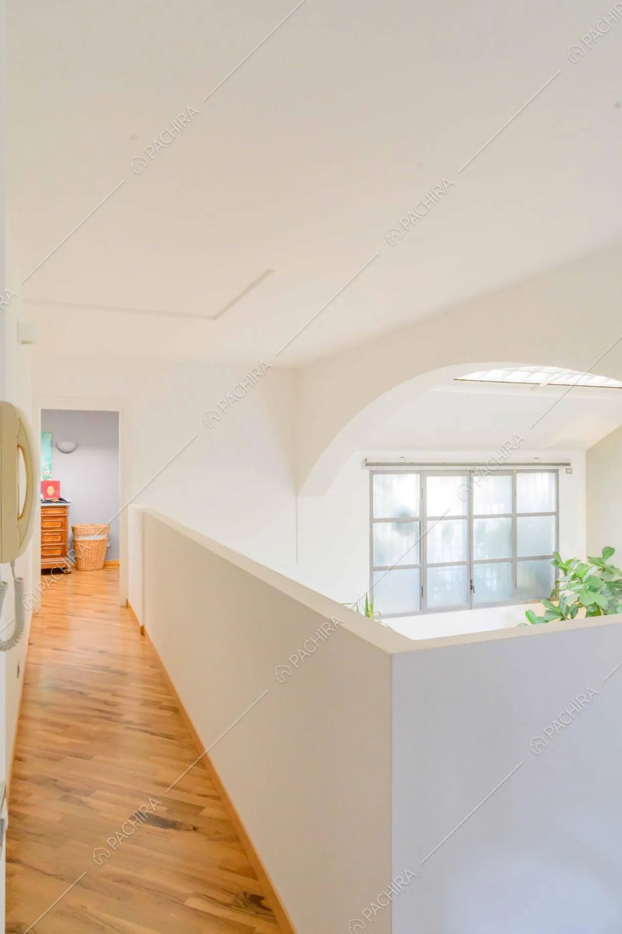 Soppalco con pavimento in parquet e pareti e soffitto bianchi