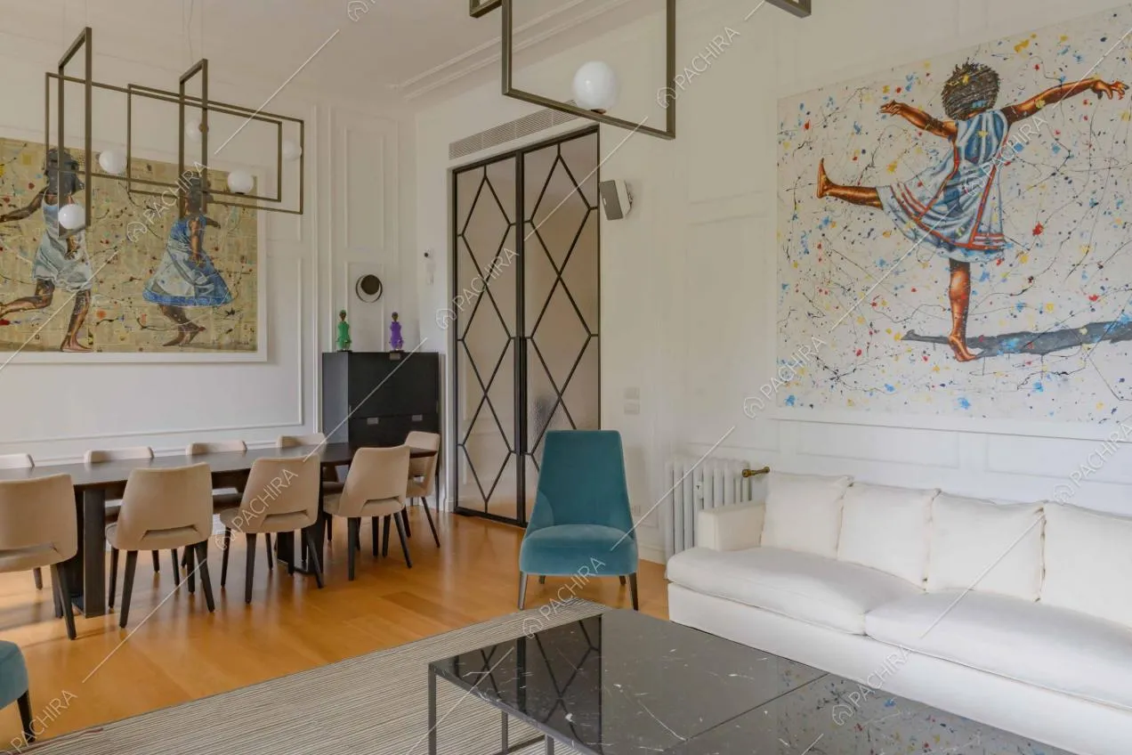 Tavolino nero di design nel soggiorno con divani bianchi e tavolo da pranzo