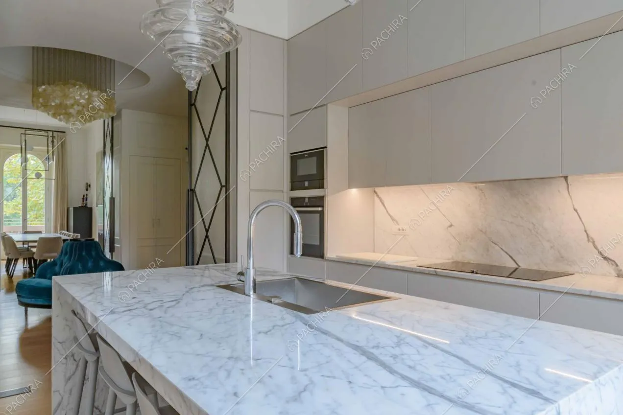 Dall'isola della cucina con sgabelli vista sul soggiorno con tavolo da pranzo