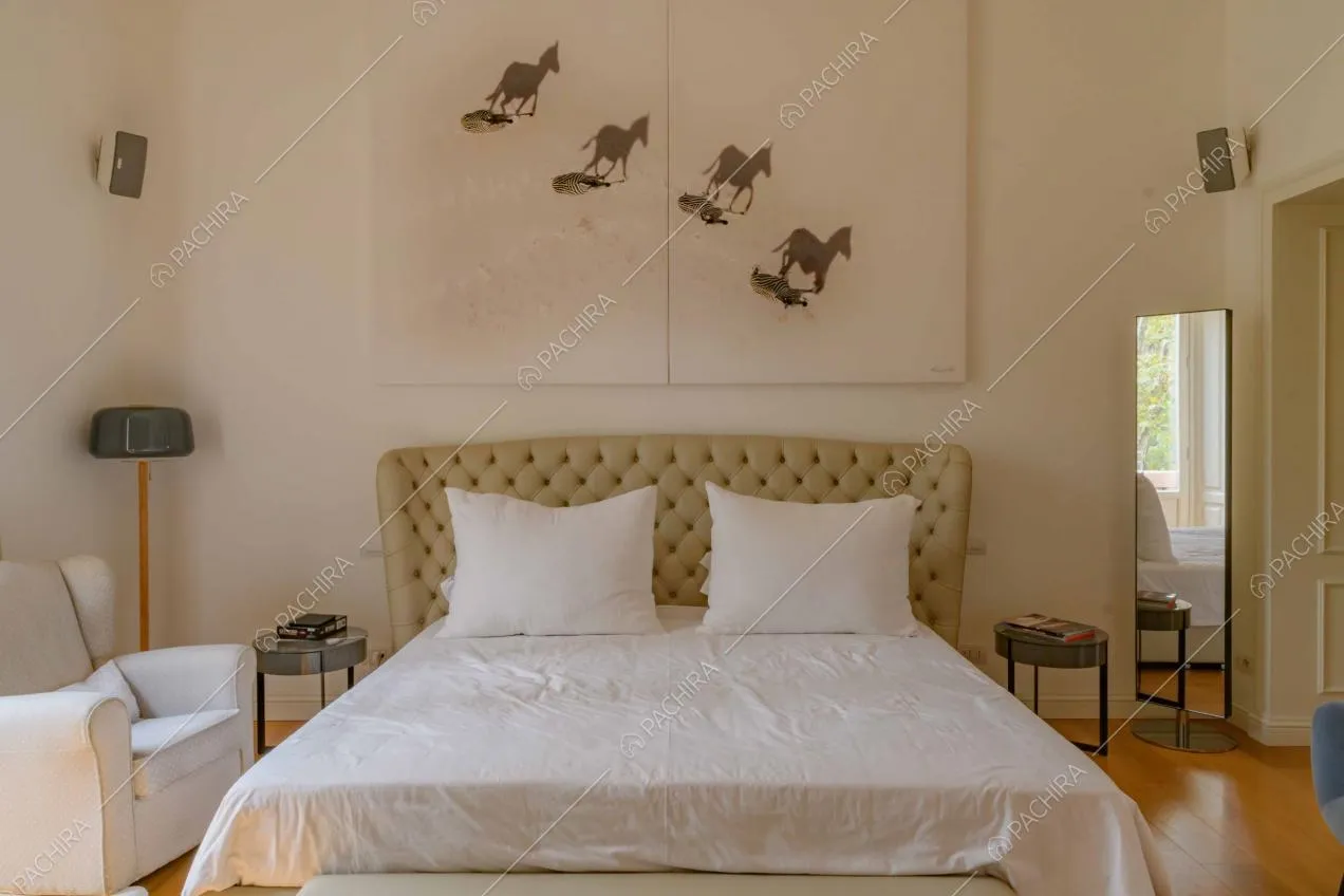 Pareti bianche e pavimento in parquet nella camera da letto matrimoniale