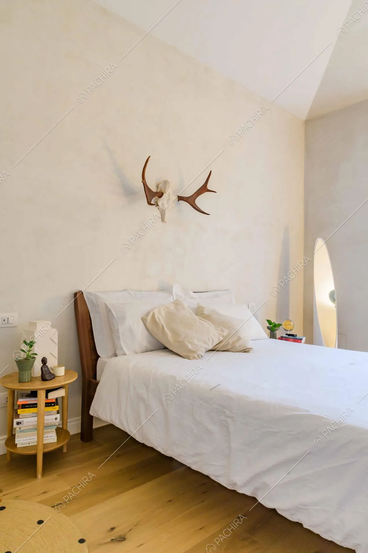 Luminosa camera da letto matrimoniale con pavimento in parquet e pareti bianche