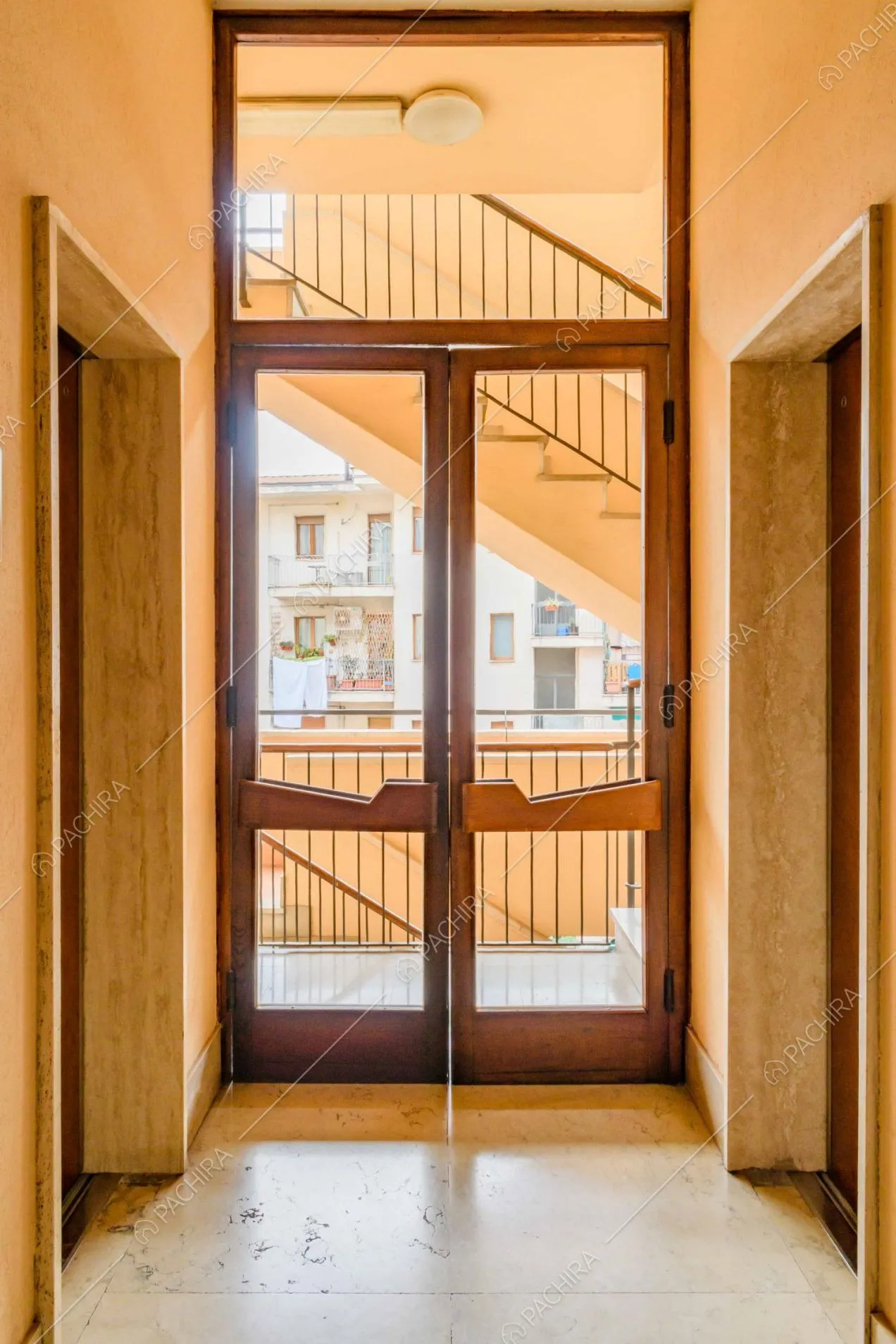 Atrio dell'appartamento con vista sul corridoio e sulle scale del condominio