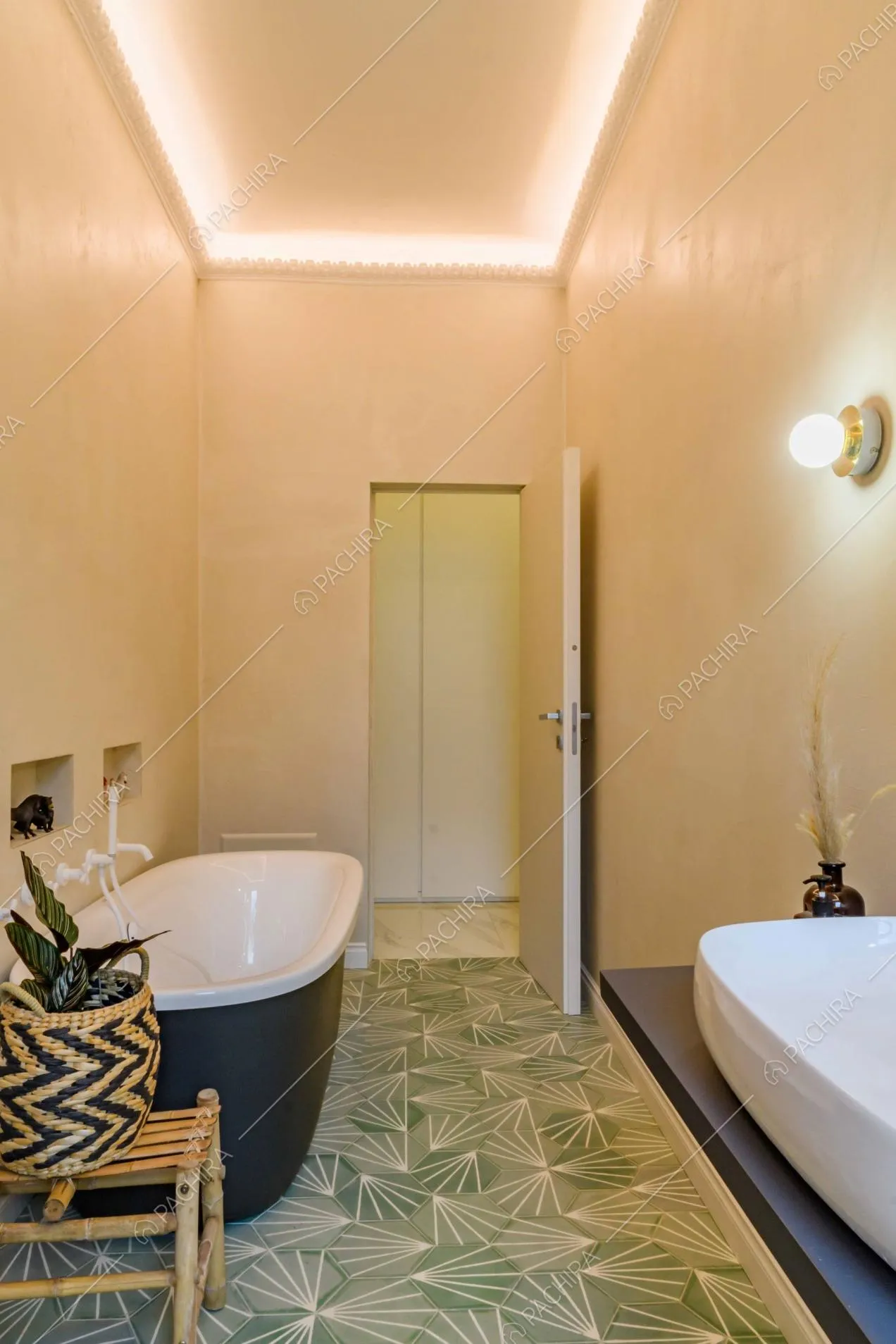 Bagno con piastrelle cemetine verdi, vasca blu e pareti bianche