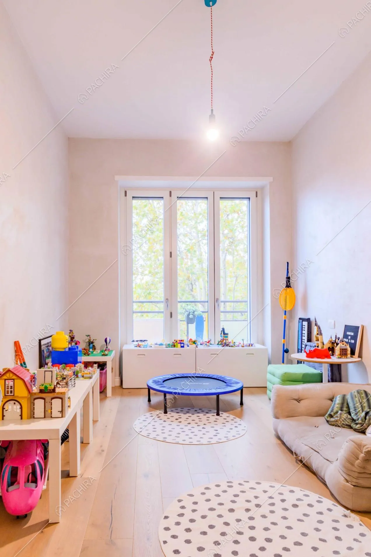 Camera da letto da bambini con pavimento in parquet, giochi e grandi porte-finestre