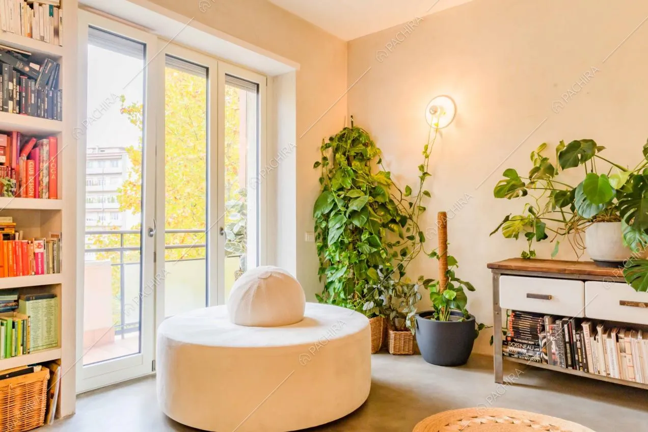 Pouf bianco nel salotto con porte-finestre con accesso al balcone