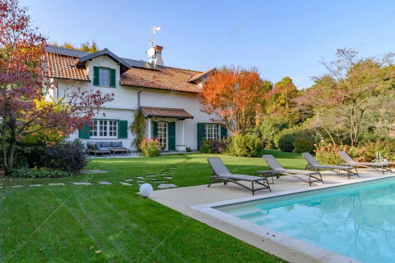 Curato giardino con piscina e vista sulla villa dagli esterni bianchi