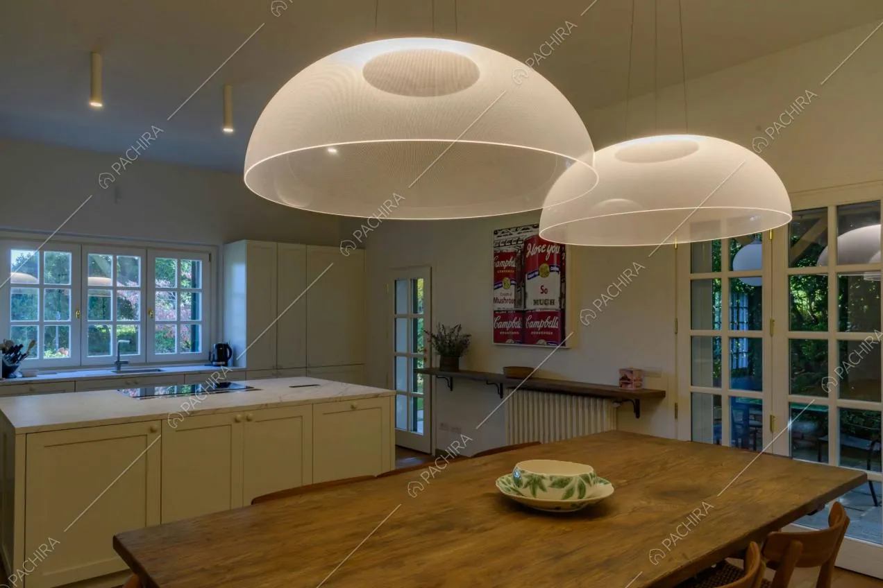 Lampadari di design sul tavolo da pranzo in legno della cucina a vista e a isola