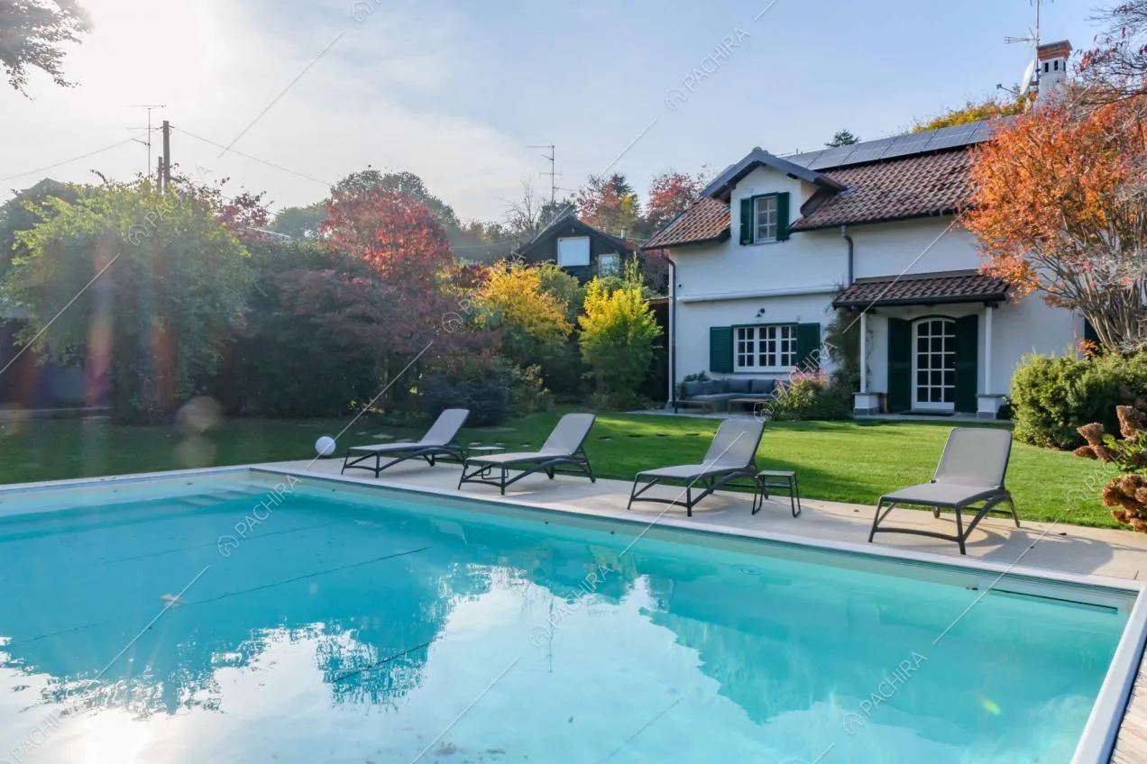 Meravigliosa piscina nel curatissimo giardino della villa dagli esterni bianchi