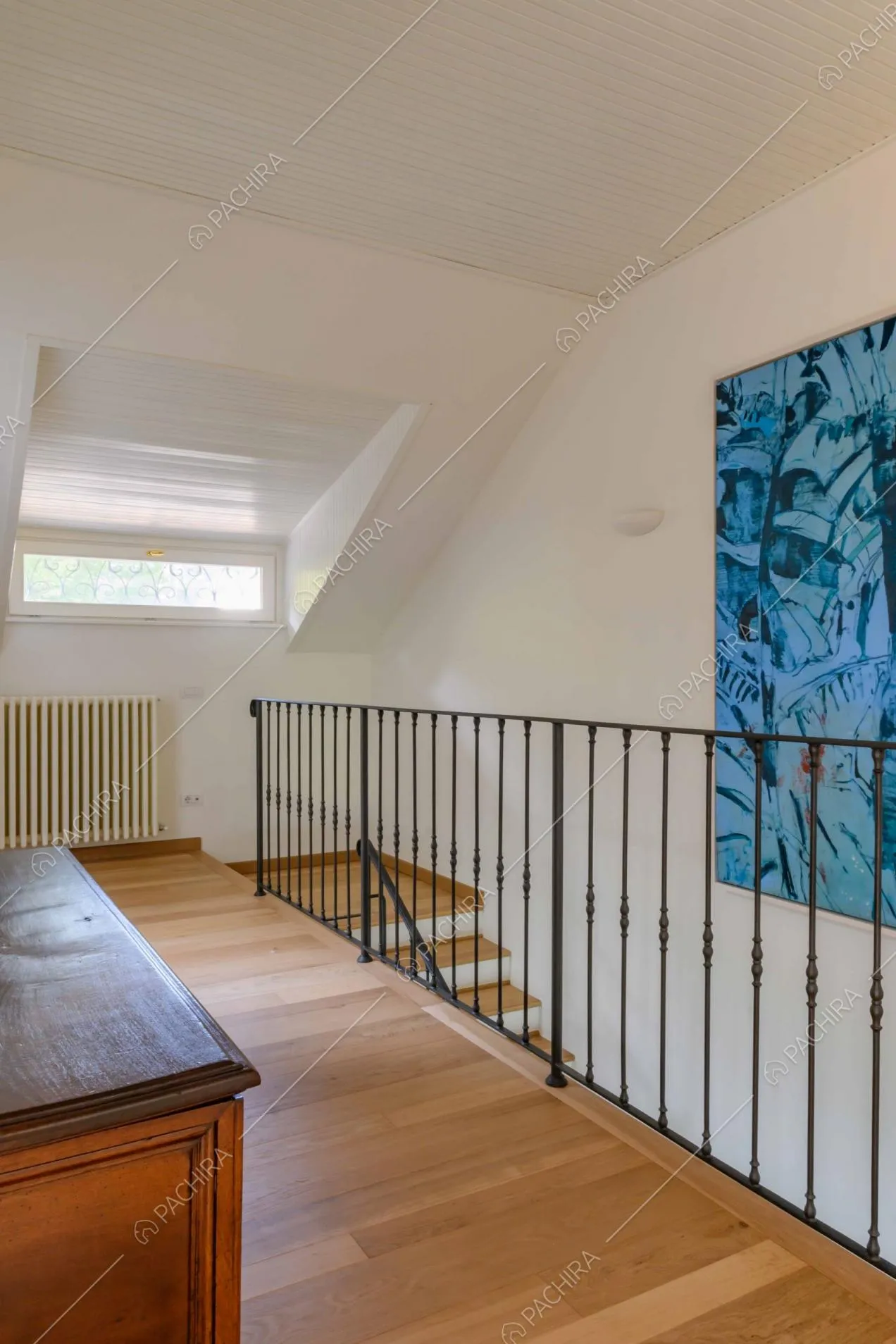 Pavimento in parquet, pareti bianche e lucernaio al piano superiore della villa
