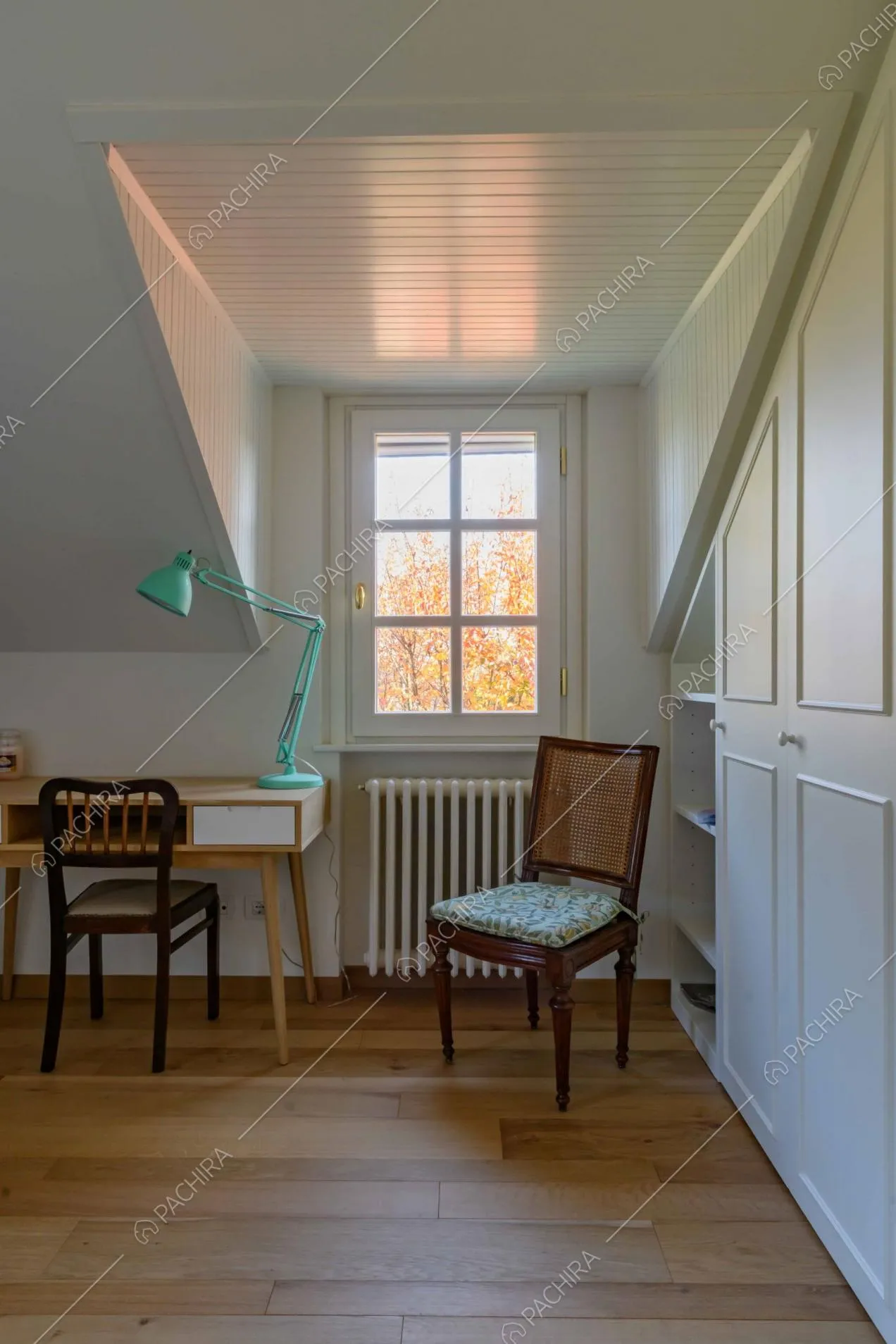 Camera con pavimento in parquet a listoni, armadio a muro con boiserie e scrivania