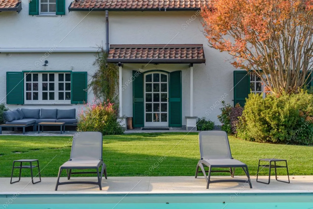 Dalla piscina vista sui letti e su porta d'ingresso e finestre dalle persiane verdi