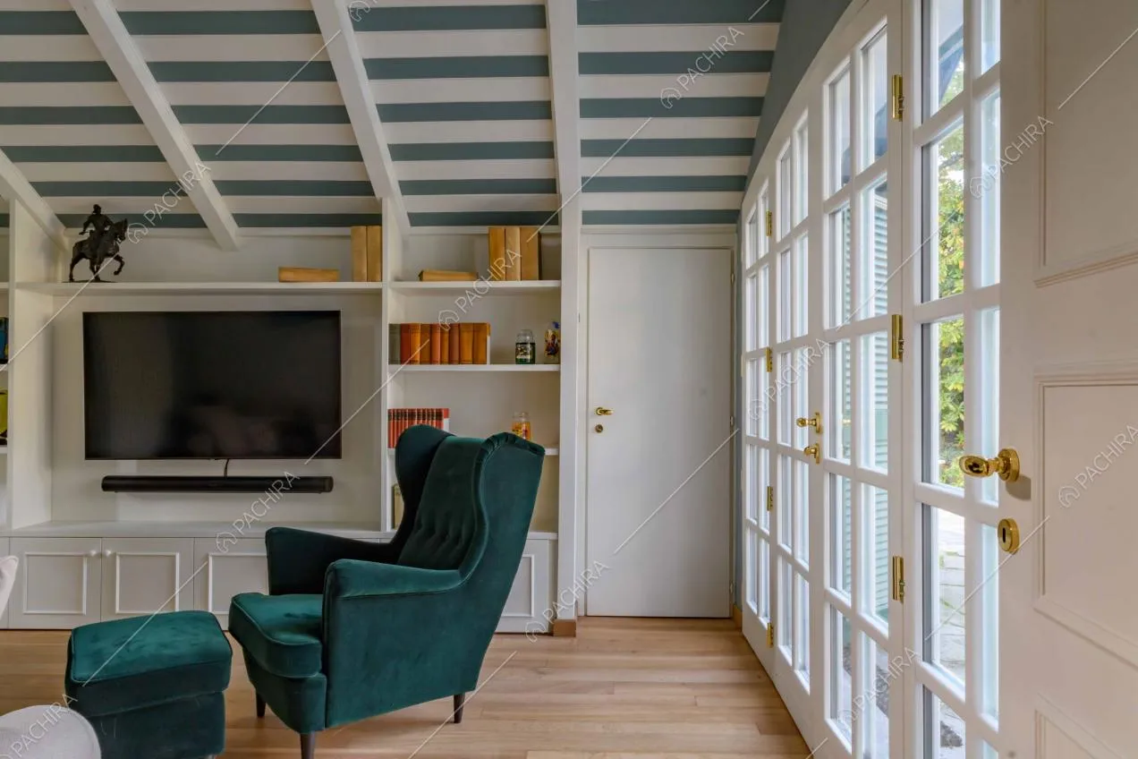 Luminoso salotto con pavimento in parquet, porta-finestra che conduce al giardino e soffitto a righe bianche e blu e con travi in legno a vista