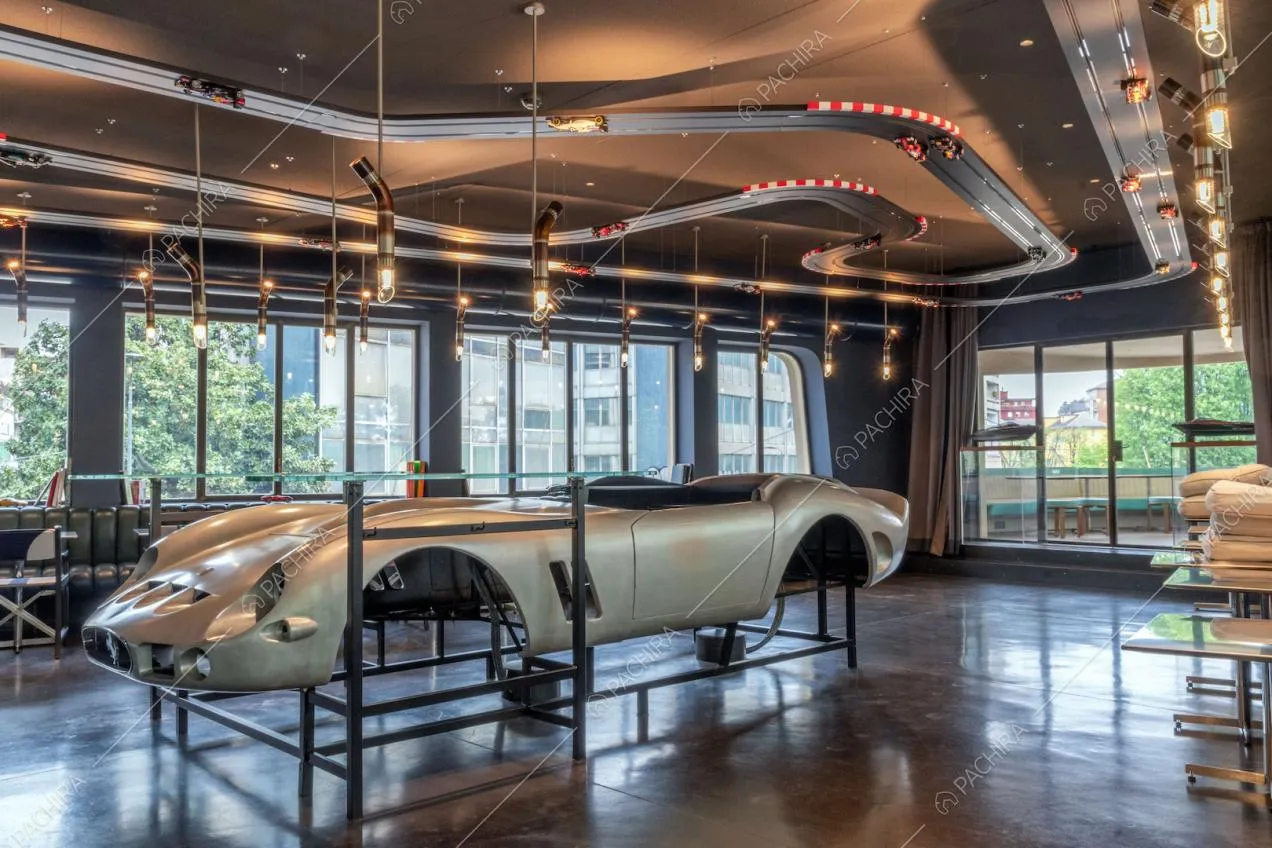 Telaio di un'automobile nella sala con grandi vetrate e pista per macchinine sul soffitto