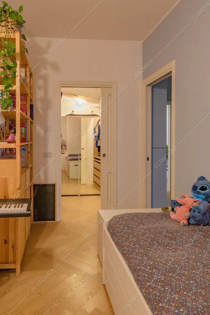 Camera da letto con pavimento in parquet a spina di pesce e cabina armadio
