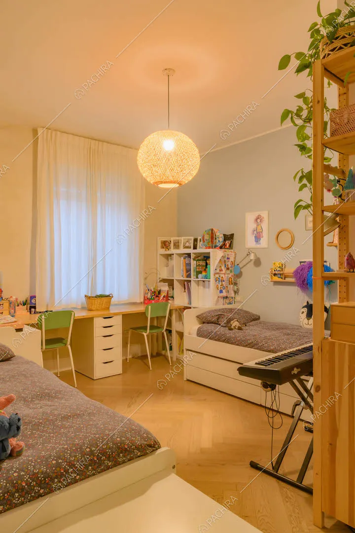 Camera da letto con scrivania, libreria e pavimento in parquet a spina di pesce