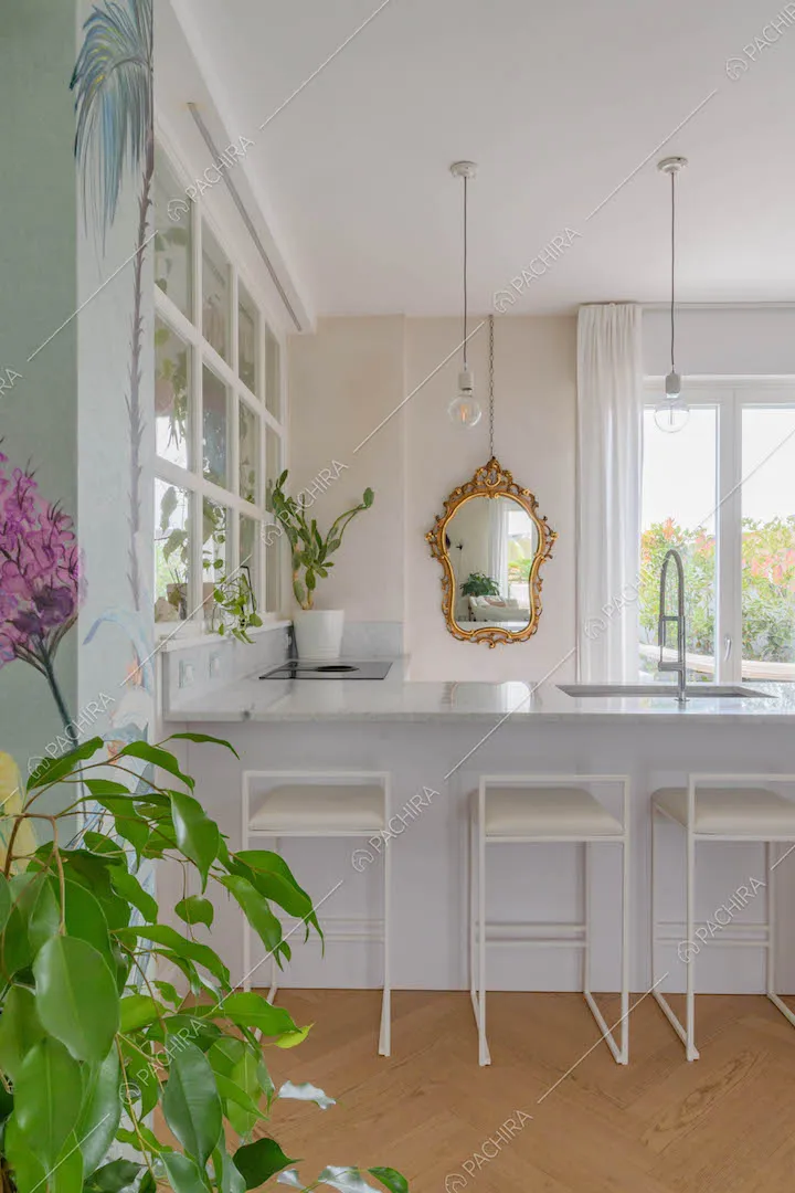 Penisola bianca della cucina con lavandino e sgabelli nell'open space con pavimento in parquet