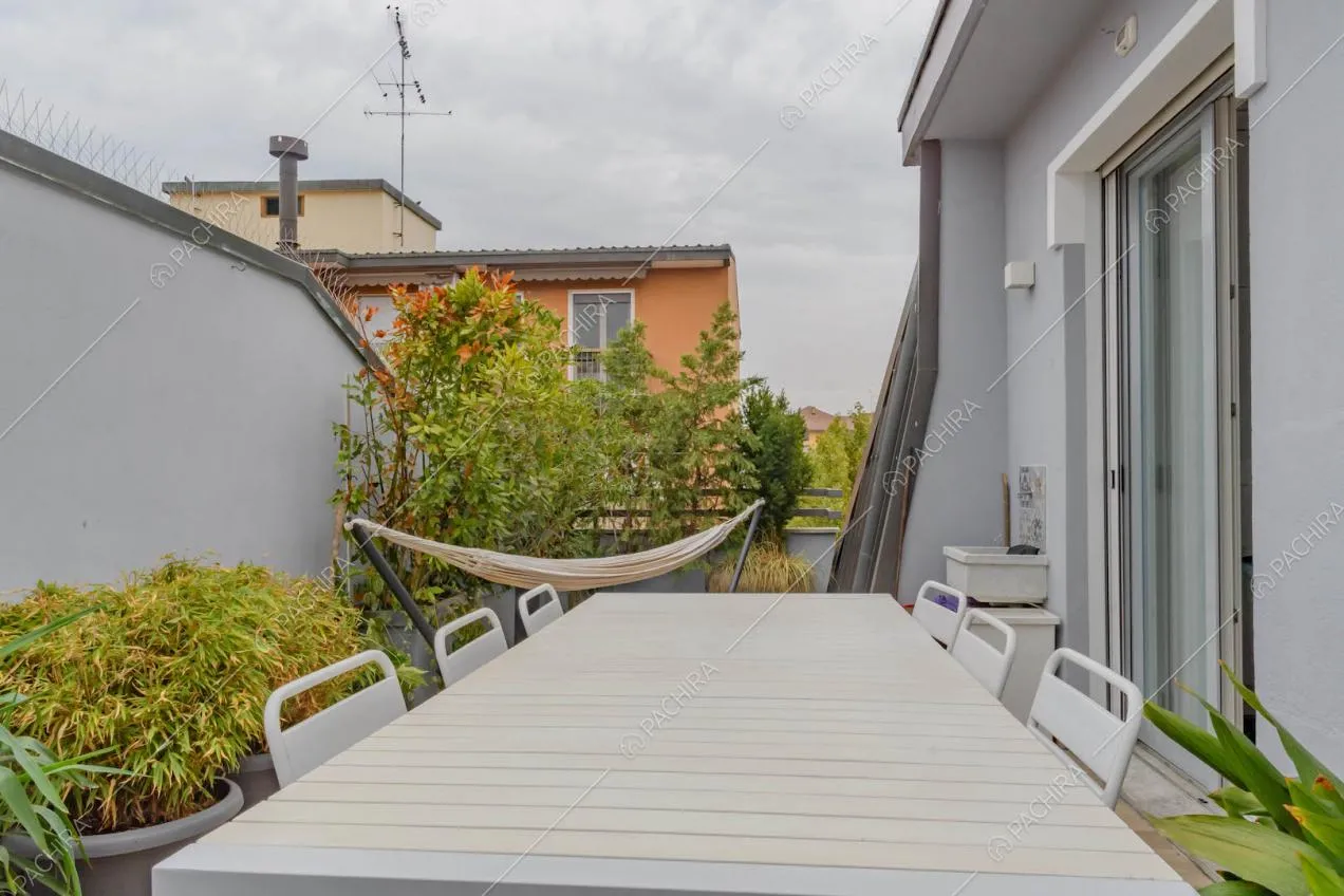 Terrazza con amaca, tavolo da pranzo e sedie bianche