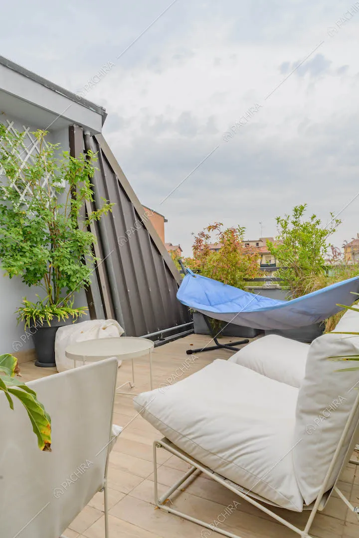 Divani bianchi sulla terrazza con pavimento in parquet e vista sullo skyline
