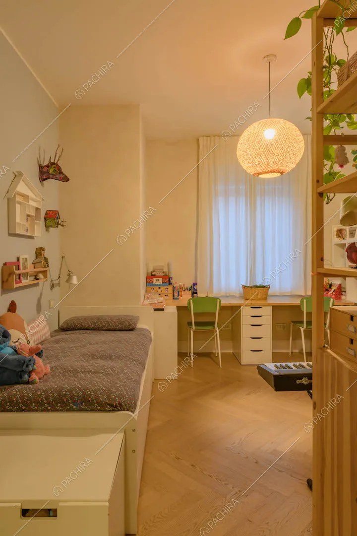 Letto singola nella camera con pareti azzurre e pavimento in parquet a spina di pesce