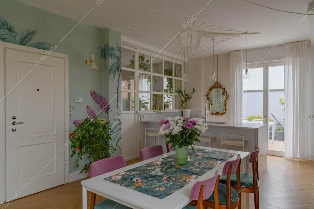 Tavolo da pranzo nell'open space con pavimento in parquet a spina di pesce e carta da parati