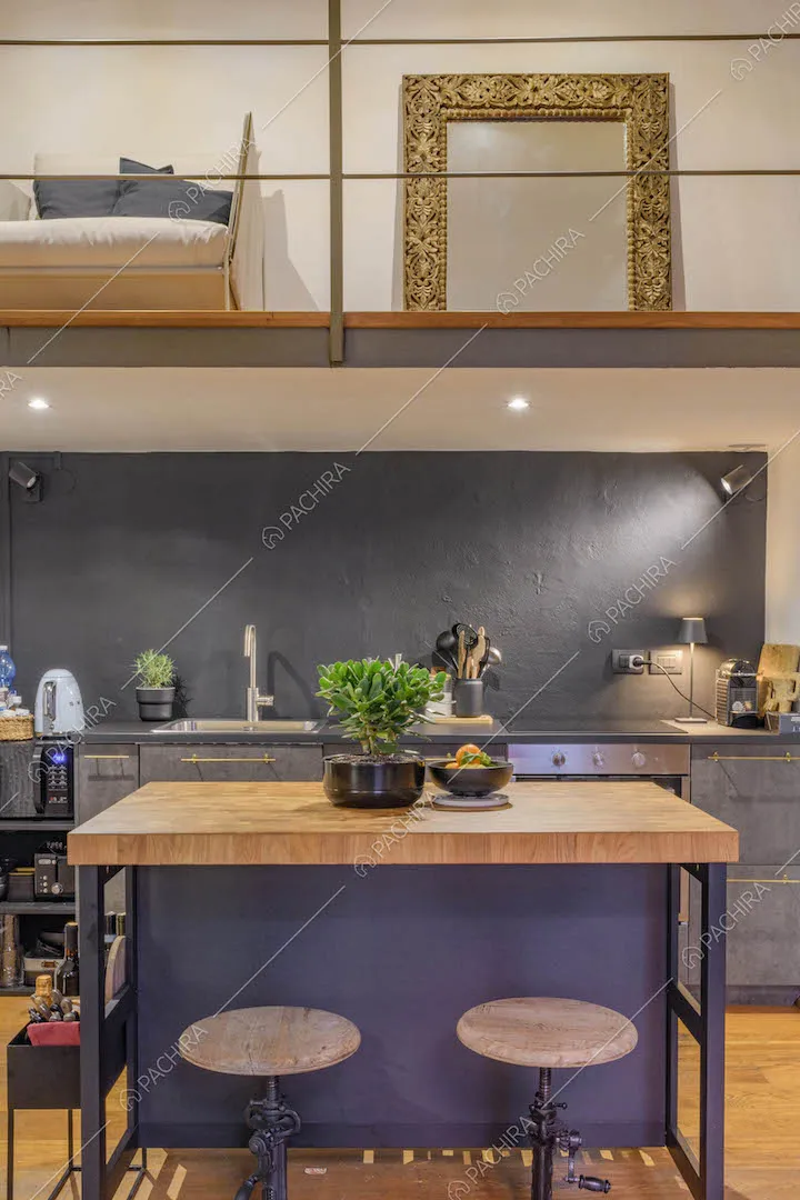 Isola con bancone in legno, sgabelli e parete grigia della cucina