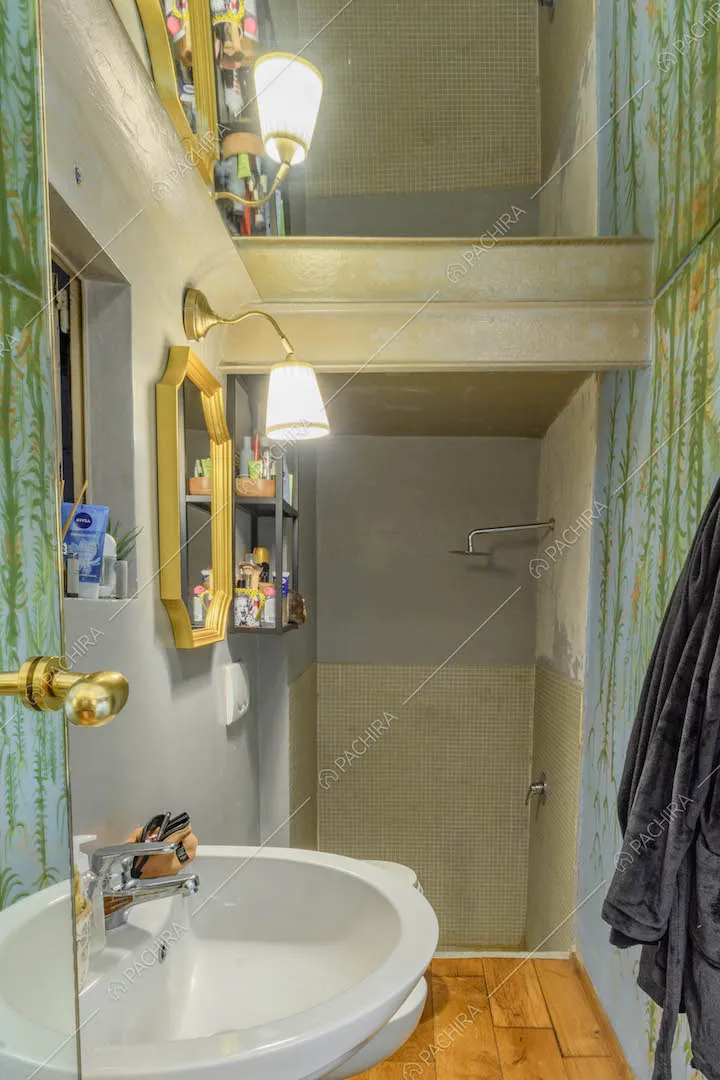 Bagno con specchio sul soffitto, pavimento in parquet e box doccia