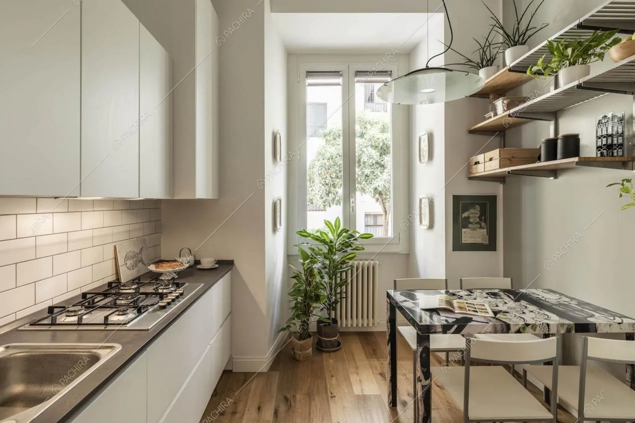 Cucina a parete con pavimento in parquet, fornelli a gas e paraschizzi in mattonelle bianche