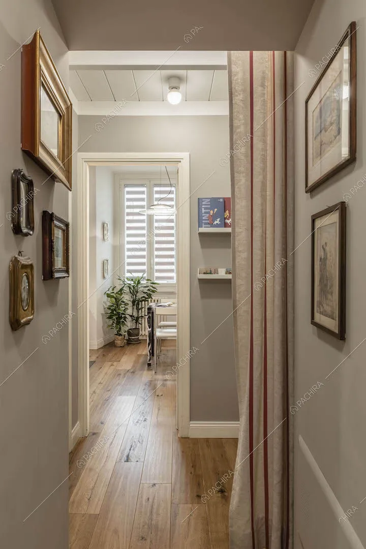 Corridoio dalle pareti grigie e dal pavimento in parquet