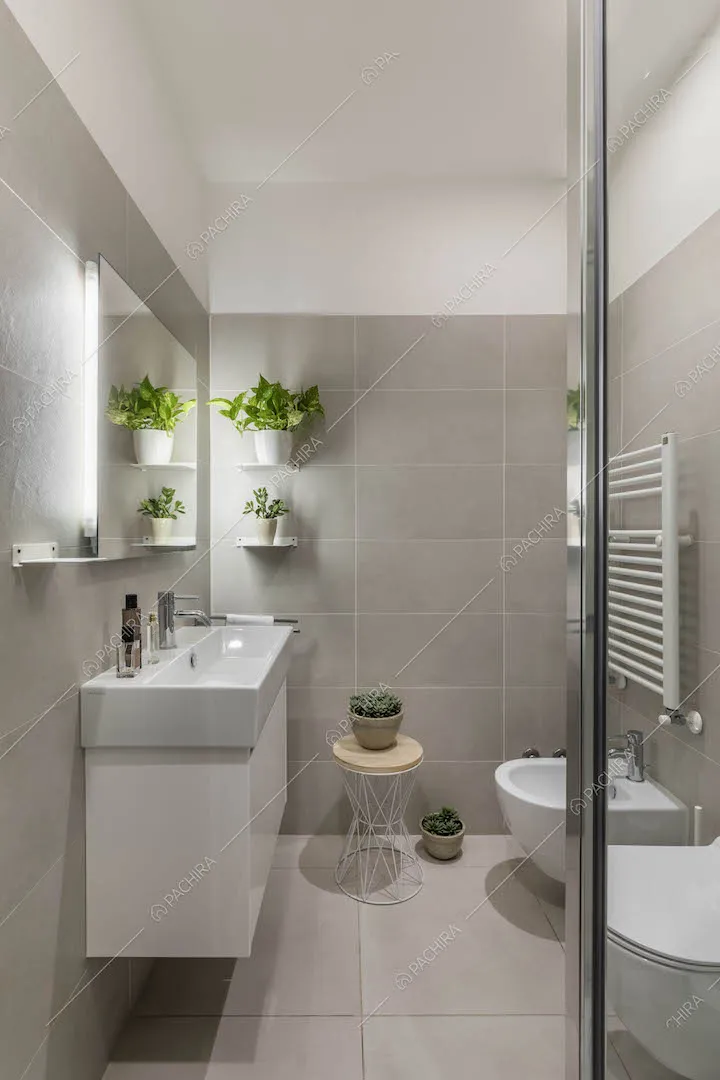 Bagno con mobile sospeso e piastrelle grigie su pareti e pavimento