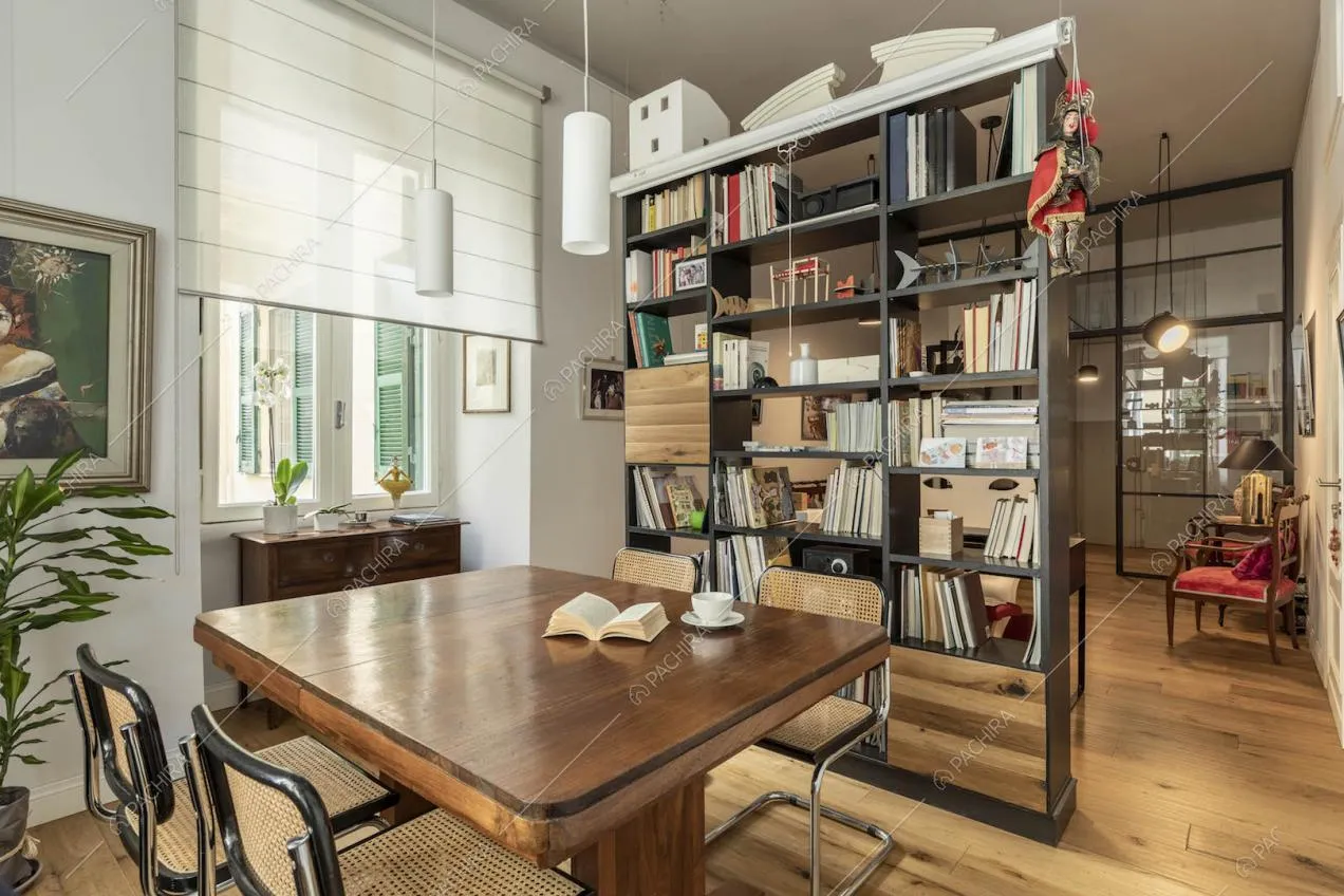 Dal tavolo da pranzo vista sulla libreria divisoria e sull'ingresso