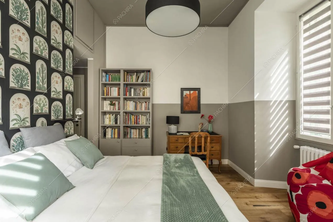 Camera da letto matrimoniale con soffitto grigio, pavimento in parquet e libreria