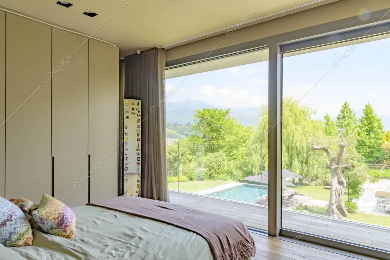 Camera da letto con pavimento in parquet, armadi a muro e porta-finestra scorrevole che conduce al balcone