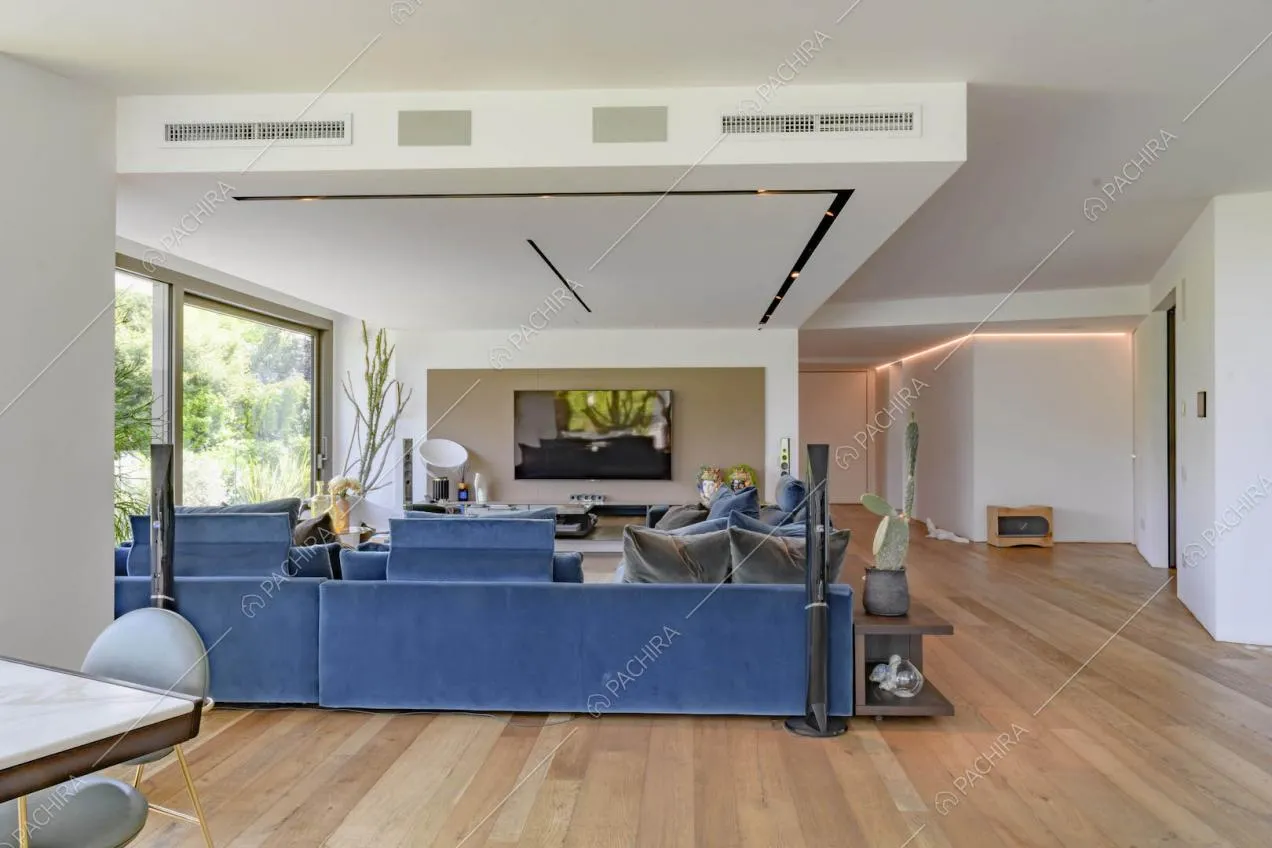 Pavimento in parquet nella luminosa sala con divani blu e grandi vetrate