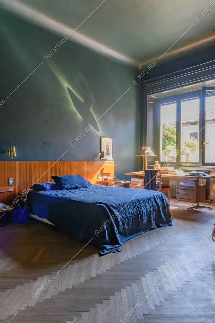 Camera da letto matrimoniale con pavimento in parquet a spina di pesce e pareti blu