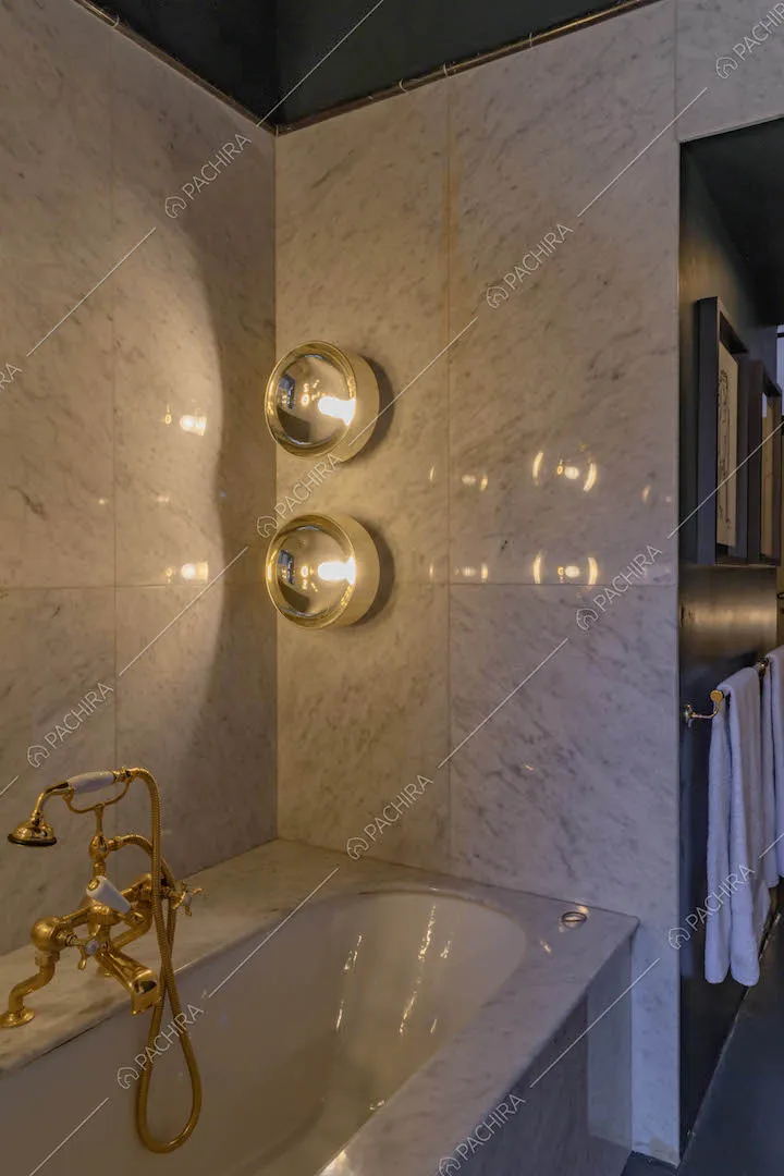Vasca nel bagno con pareti in marmo e soffitto blu