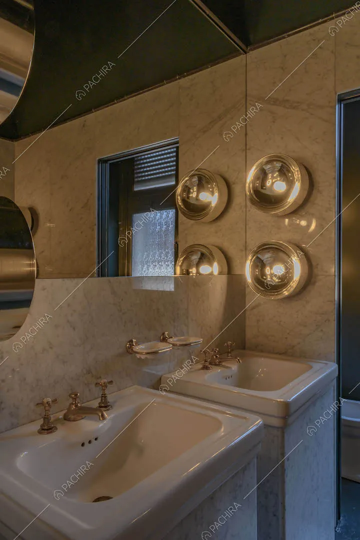 Doppio lavandino nel bagno con parete in marmo e soffitto blu