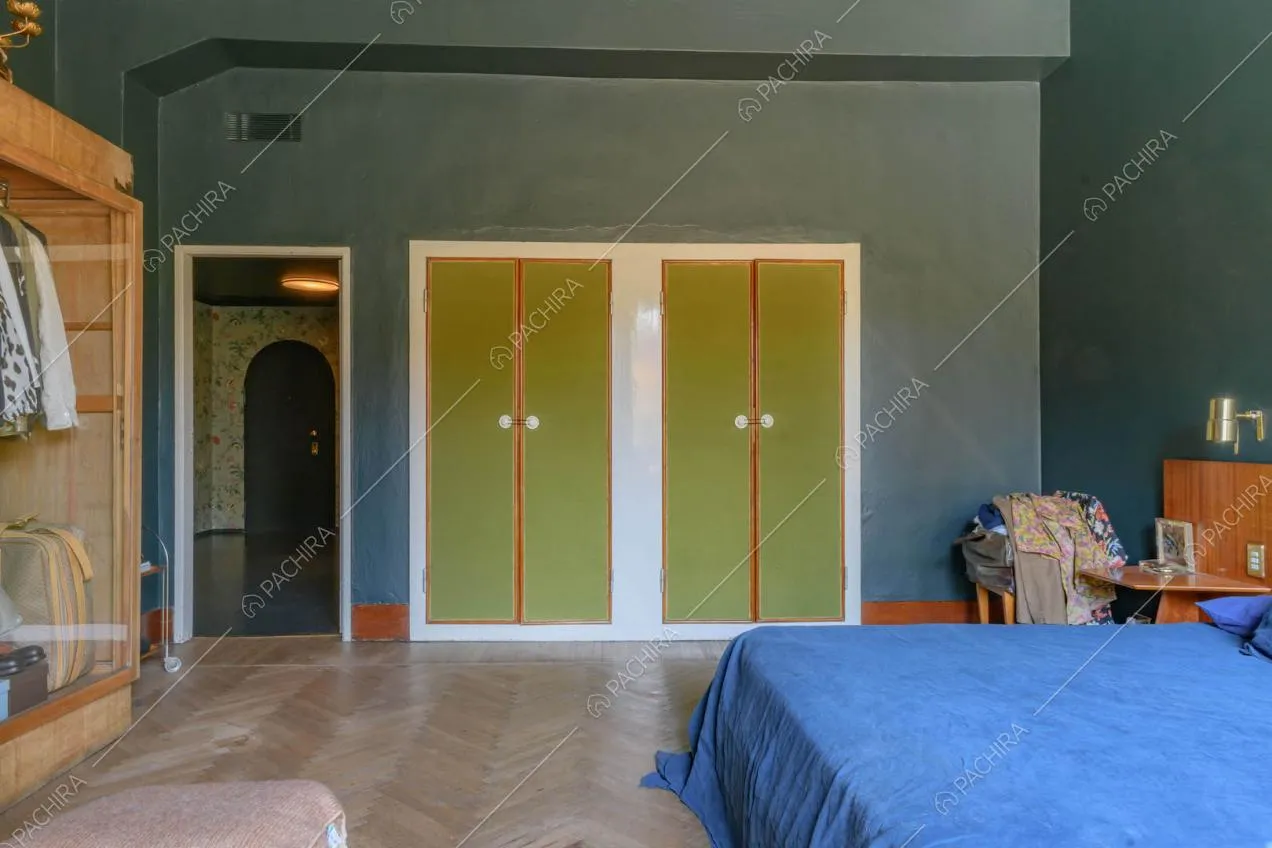Camera da letto matrimoniale con pavimento in parquet a spina di pesce e pareti blu