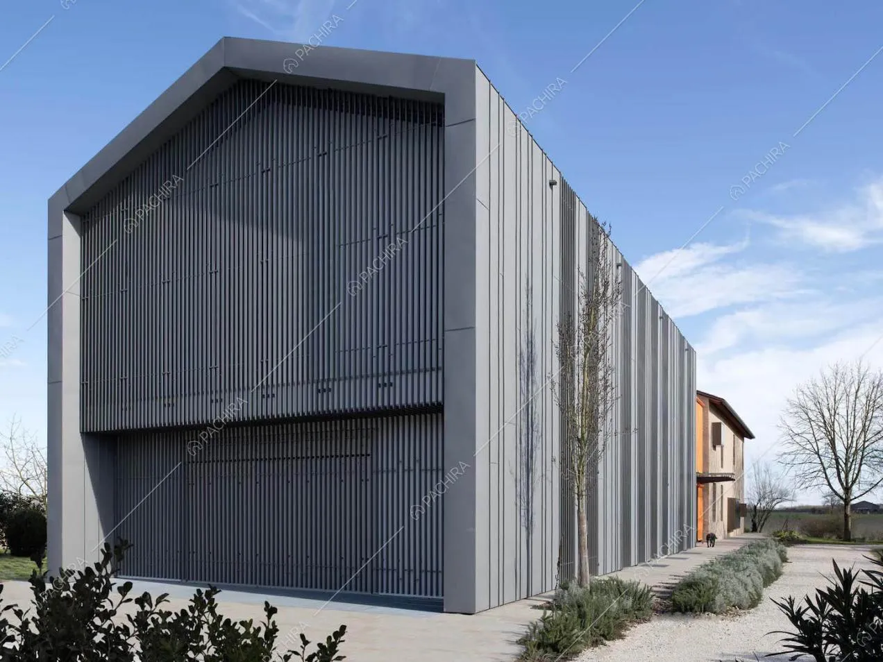 Esterni in stile industriale visti dal giardino della villa