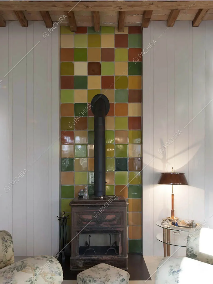 Salotto con stufa su mattonelle colorate, pareti bianche e poltrone