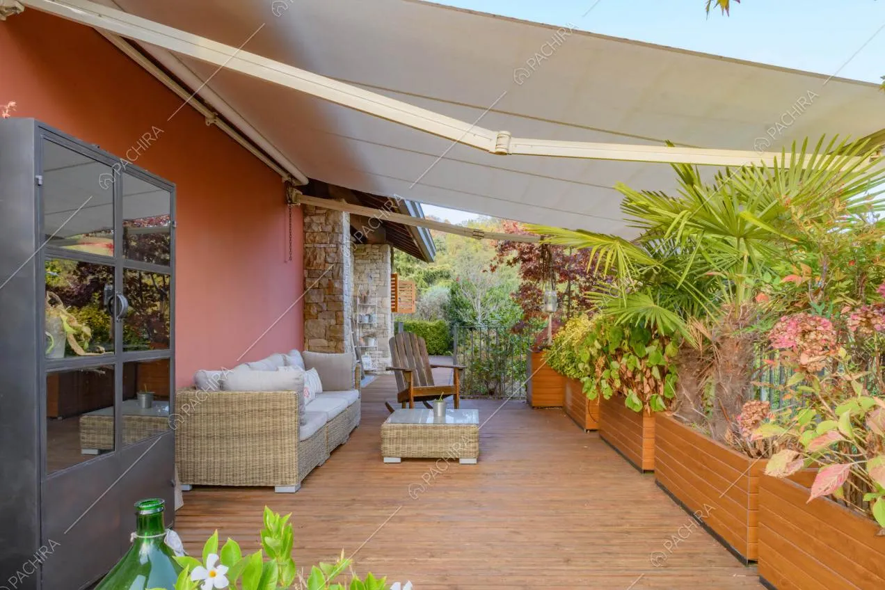 Pavimentazione in parquet nella terrazza con esterni rossi e colonne in pietra