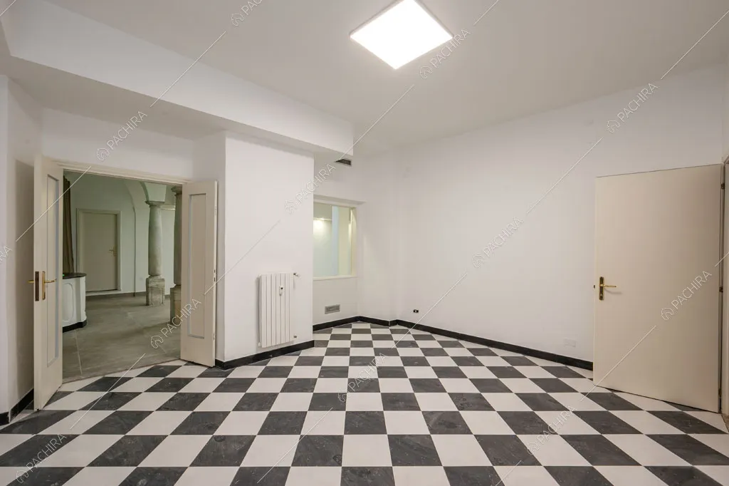 Pavimento a scacchi nella sala con pareti bianche