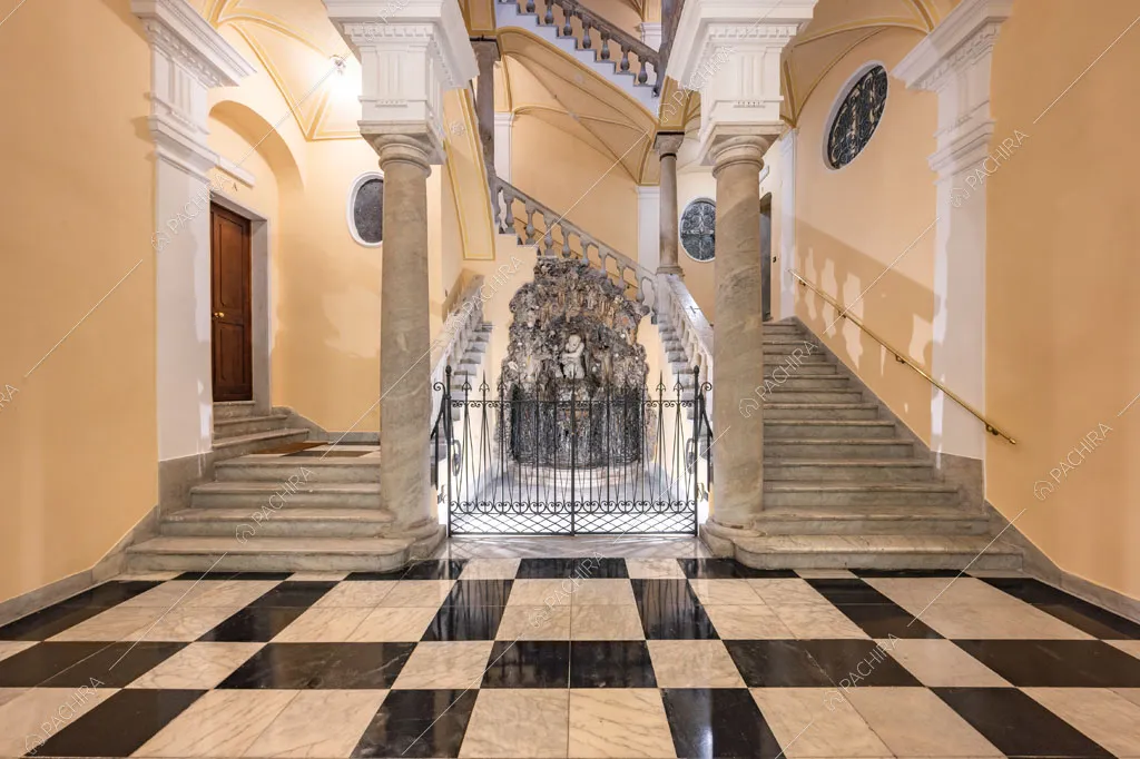 Atrio monumentale della location con pavimento in marmo a scacchi, scale e colonne