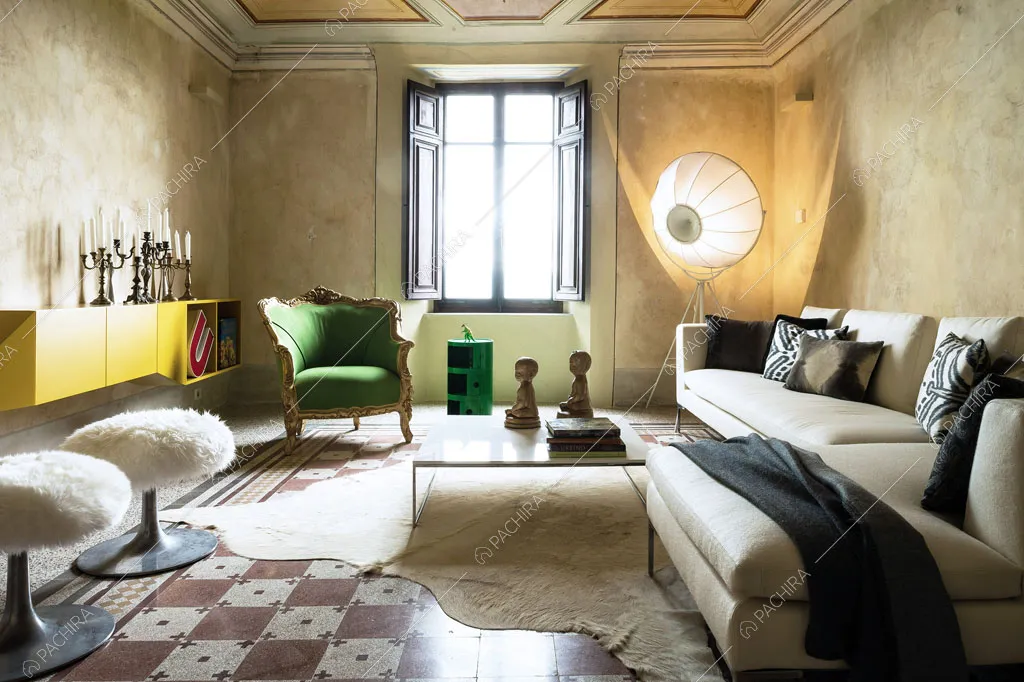 Luminoso salotto con pareti beige délabré, arredo di design e pavimento con fantasia geometrica