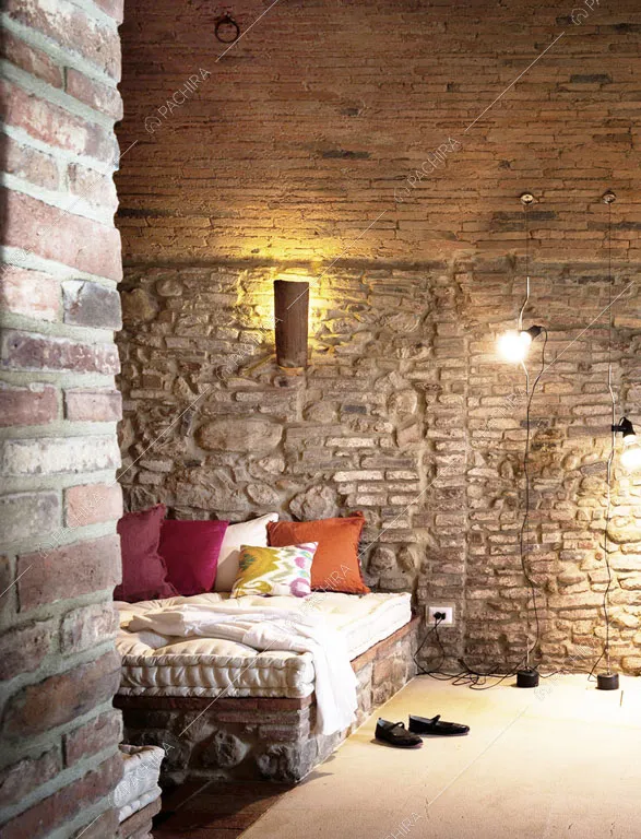 Pareti in mattoni e pietra a vista nella camera da letto matrimoniale