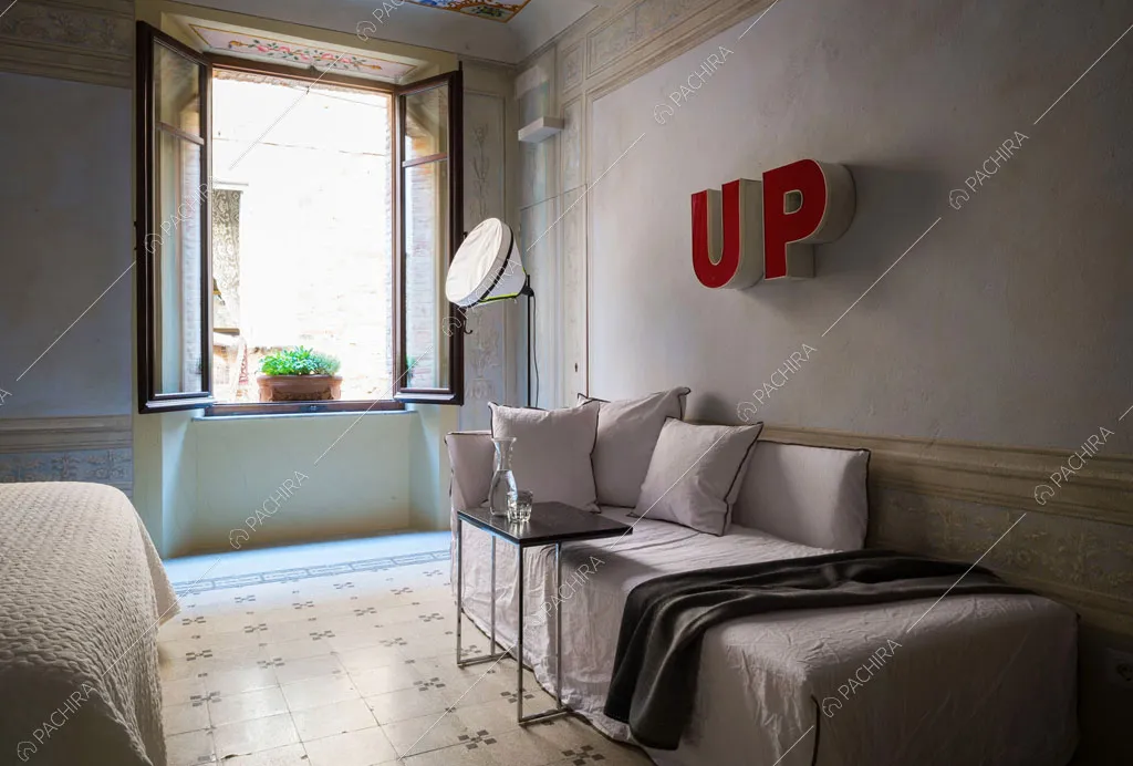 Pouf nella camera da letto matrimoniale con pavimento a fantasia geometrica