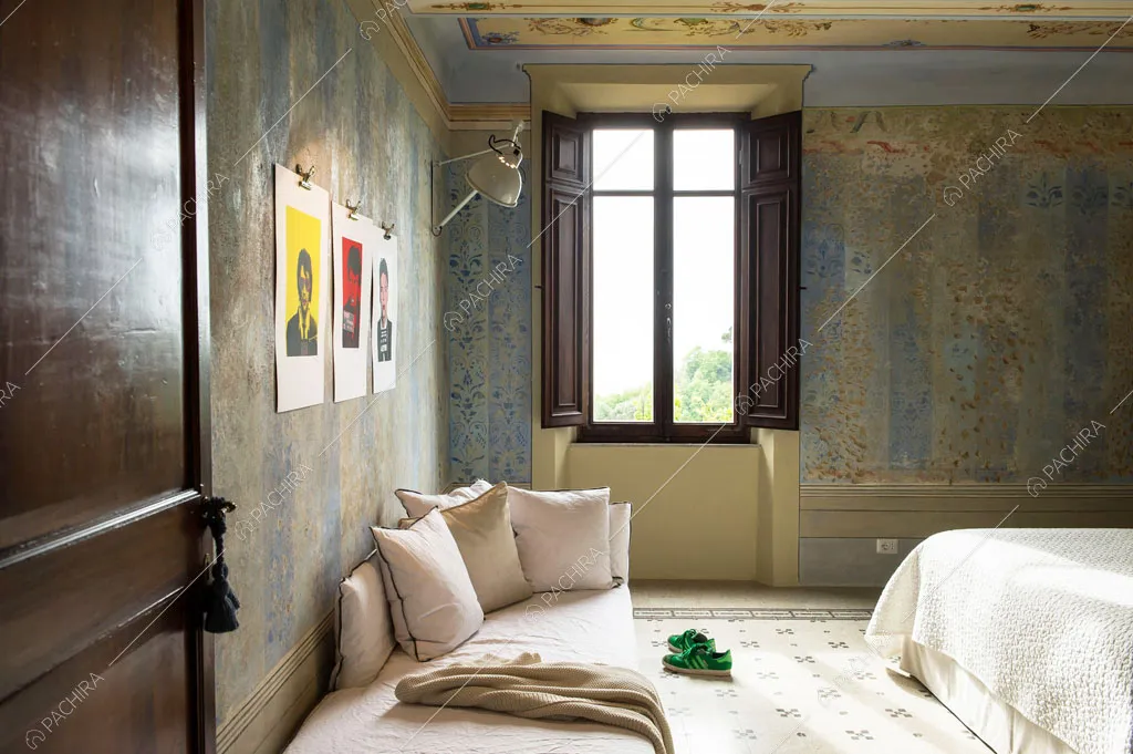 Pouf nella camera da letto matrimoniale con pareti délabré affrescate gialle e azzurre