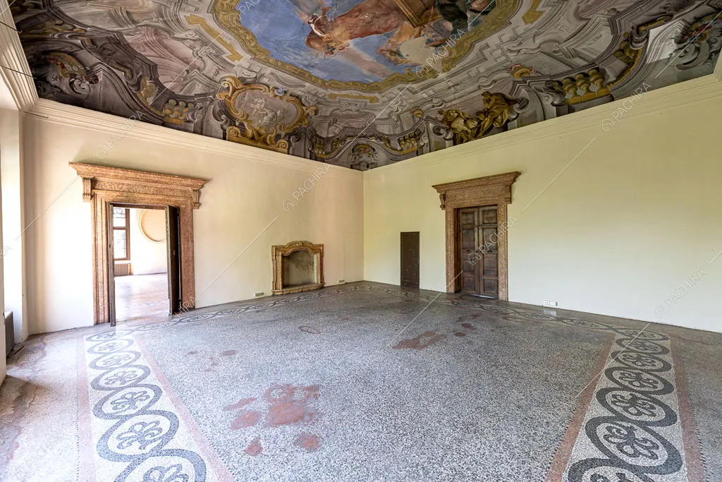 Luminoso salone con pavimento in graniglia, pareti bianche e soffitto affrescato